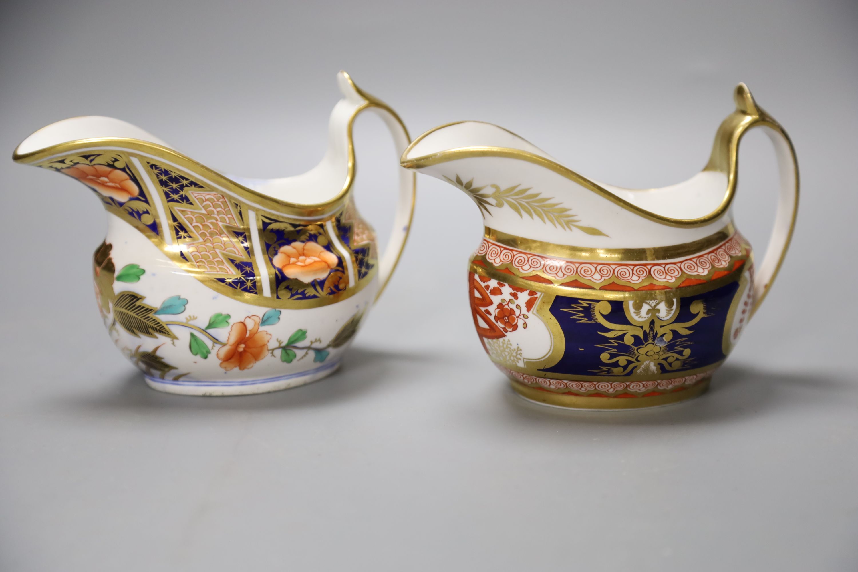 A Spode cream jug painted in imari style with the dollar pattern 715 and another Spode cream jug painted in imari style